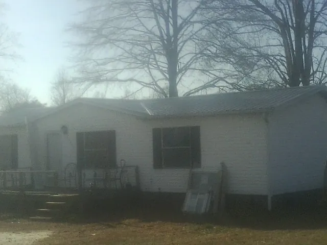 New metal roof on a white painted brick home on a foggy morning in Robbins